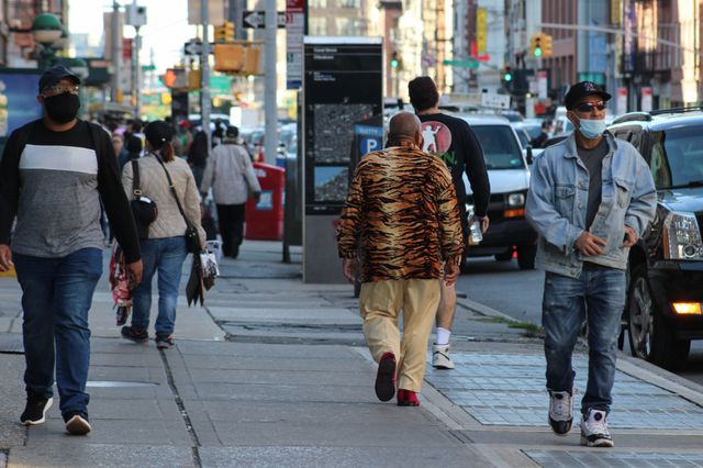A photo of a man walking on Canal Street with a cool jacket on